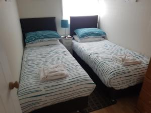 two beds sitting next to each other in a room at 28 Riverside, Caer Beris Holiday Park in Builth Wells