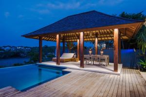 a pavilion with a table and chairs on a deck at Villa Tranquilla in Nusa Lembongan