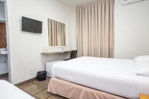 um quarto de hotel com duas camas e uma televisão em Panorama Convention Hotel em Coronel Fabriciano