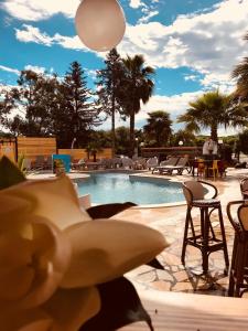 a swimming pool with chairs and a table and a ball at Le Banana's in Aléria