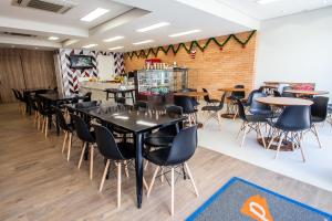 a dining room with black tables and chairs at Panorama Convention Hotel in Coronel Fabriciano