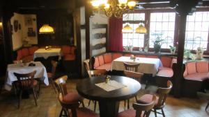 a restaurant with two tables and chairs and windows at Hotel Rose in Warburg