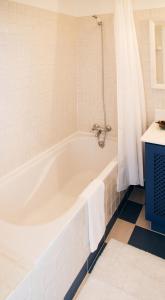 a white bath tub in a bathroom with a blue cabinet at Casa da Manta in Fajã da Ovelha