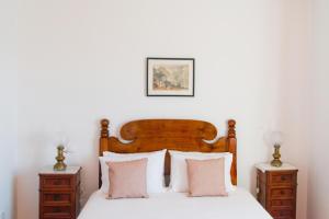 a bedroom with a wooden bed with two night stands at Casa da Manta in Fajã da Ovelha