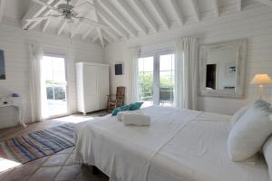 a white bedroom with a large bed with a ceiling fan at El Caprichio in Gaucín +46 photos