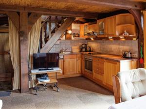 a kitchen with wooden cabinets and a tv in it at Heritage Holiday Home In Wienhausen near River in Langlingen