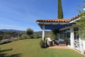a house with a blue roof and a lawn at El Caprichio in Gaucín