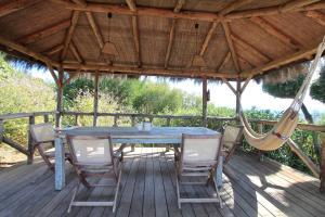 a table and chairs on a deck with a hammock at El Caprichio in Gaucín