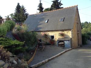 una pequeña casa de ladrillo con una chimenea frente a ella en The Grange en Les Portes du Coglais