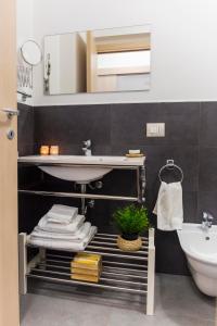 a bathroom with a sink and a toilet and a mirror at MareinSicilia: Appartamenti Larica in Cava D'aliga