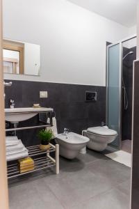 a bathroom with a toilet and a sink and a tub at MareinSicilia: Appartamenti Larica in Cava D'aliga