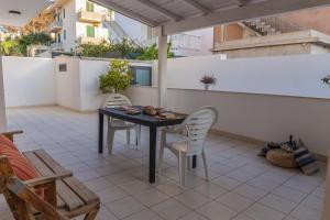 patio con mesa y sillas en el balcón en MareinSicilia: Appartamenti Larica, en Cava dʼAliga