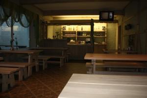 an empty restaurant with wooden tables and a bar at Zīriņi in Kolka