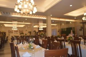 a dining room with tables and chairs and a chandelier at Sea Garden Resort Iloilo in Iloilo City