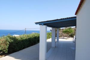 a covered walkway with the ocean in the background at BAY VIEW STUDIO in Megas Gialos - Nites