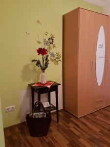 a table with a vase with flowers on it next to a door at City Lodge Apartment in Leipzig