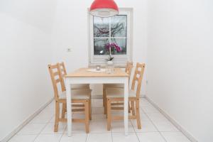 a dining room table with four chairs and a window at Ferienwohnung BadSaarowZentrum in Bad Saarow