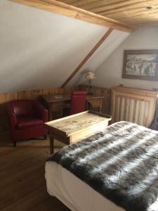 a bedroom with a bed and a desk and a chair at Hôtel Restaurant de la Chaussée in Briançon
