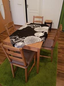 a wooden table with two chairs and a bed at City Lodge Apartment in Leipzig