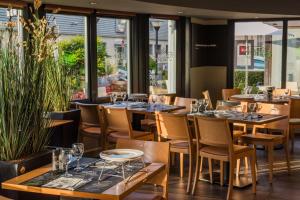 a restaurant with tables and chairs and windows at ibis Tours Nord in Tours
