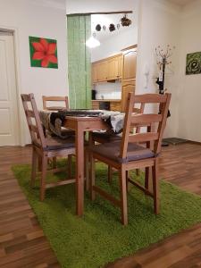 a dining room table and two chairs on a green rug at City Lodge Apartment in Leipzig