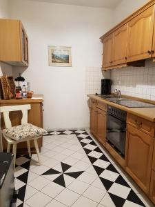 a kitchen with a black and white checkered floor at City Lodge Apartment in Leipzig