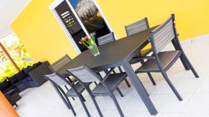 Finisterre Curaçao في Sabana Westpunt: طاولة وكراسي عليها إناء ورد