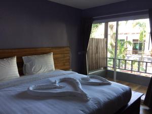 ein Schlafzimmer mit einem Bett mit zwei Handtüchern darauf in der Unterkunft Apple Beachfront Resort in Trat