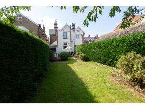 a hedge in front of a house with a yard at Sandown Villa Holiday Home in Deal