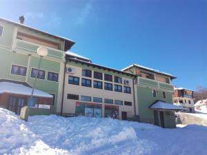 un edificio con un mucchio di neve davanti di MM Narcis a Vlasina Rid