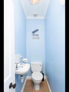 a bathroom with a white toilet and a sink at Sandown Villa Holiday Home in Deal