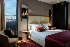a hotel room with a bed and a chair at Upon Lisbon Prime Residences in Lisbon
