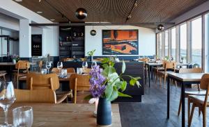 a restaurant with tables and chairs and windows at Nordlandet in Allinge