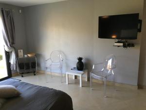 - une chambre avec trois chaises et une télévision à écran plat dans l'établissement Chambre Élégante Lisa, à Bastia