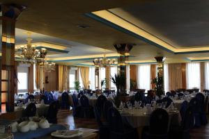 a banquet hall with tables and chairs and chandeliers at Hotel Sierra Oriente in Guadarrama