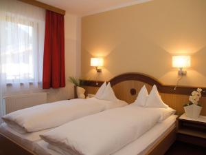 a bedroom with two white beds and a window at Haus Annakogl und Haus Barbara in Obergurgl