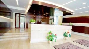 a lobby with a bar with potted plants on the floor at Apartment-Hotel Panorama in Dnipro