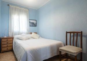 1 dormitorio con 1 cama, 1 silla y 1 ventana en Apartamento frente al mar - 500 Mbps, en Puerto Sagunto