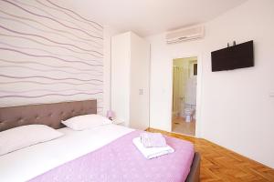 una camera con un letto con una parete rosa e bianca di Guest house Burin a Mlini