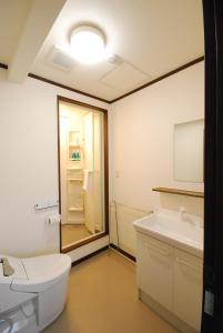 a bathroom with a toilet and a sink at Pension Lavender in Furano