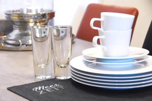 a table with plates and glasses on a table at meerZEIT Norderney in Norderney