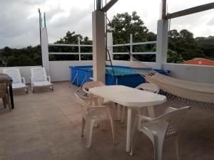 eine Veranda mit einer Hängematte sowie einem Tisch und Stühlen in der Unterkunft I BBBSAI Casa Vacacional en San Andres Islas – Alquiler in San Andrés