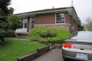 un coche aparcado frente a una casa en McMaster Accommodations, en Hamilton