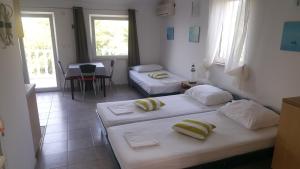 Pokój z 2 łóżkami, stołem i oknami w obiekcie Apartment Viktor w mieście Sali
