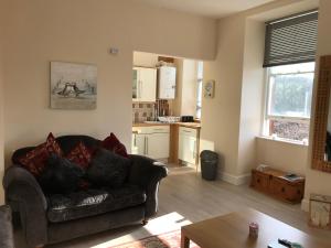 ein Wohnzimmer mit einem Sofa und einer Küche in der Unterkunft Home with a view in Moffat
