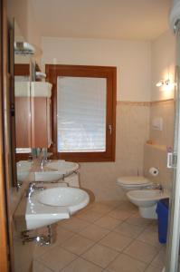 bagno con 3 lavandini e 2 servizi igienici di Appartamento Europa a Fanano