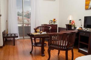 ein Wohnzimmer mit einem Tisch und 2 Stühlen in der Unterkunft Hôtel Colbert - Spa & Casino in Antananarivo
