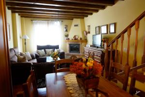 a living room with a table and a couch at CASA RURAL LA FINCA DEL POZO a 1 hora de Madrid in Segovia