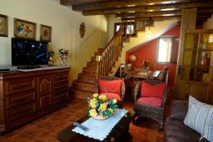 a living room with a staircase and two chairs and a table at CASA RURAL LA FINCA DEL POZO a 1 hora de Madrid in Segovia