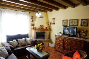 un soggiorno con divano e TV di CASA RURAL LA FINCA DEL POZO a Segovia